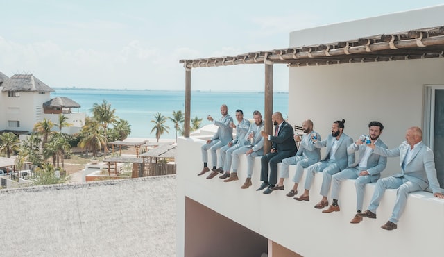 grooms men sitting on ledge