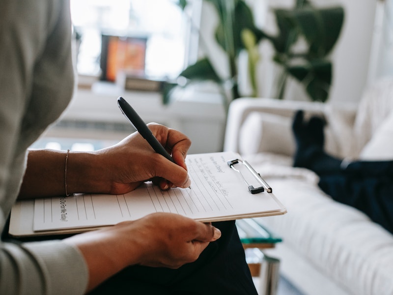 psychologist writing on clipboard during session