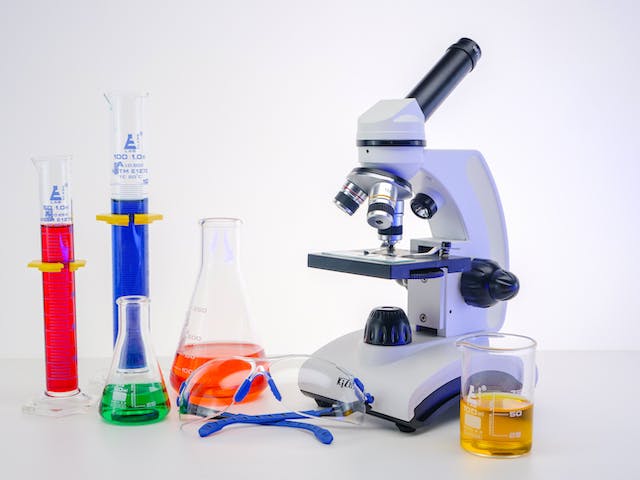 Microscope and Colorful Liquids in Laboratory Glasswares