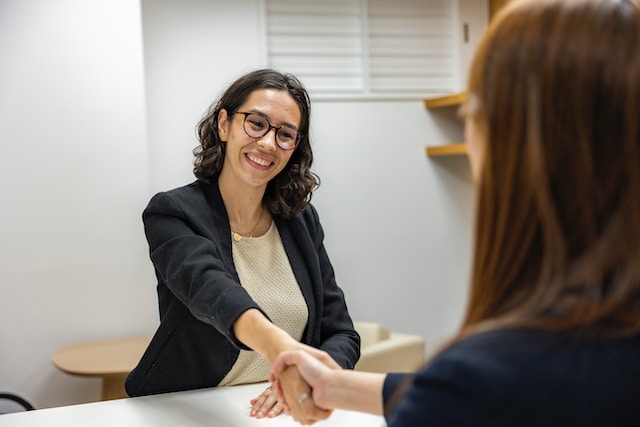 Young Woman in Business Attire Shaking Hands With Recruiting Manager